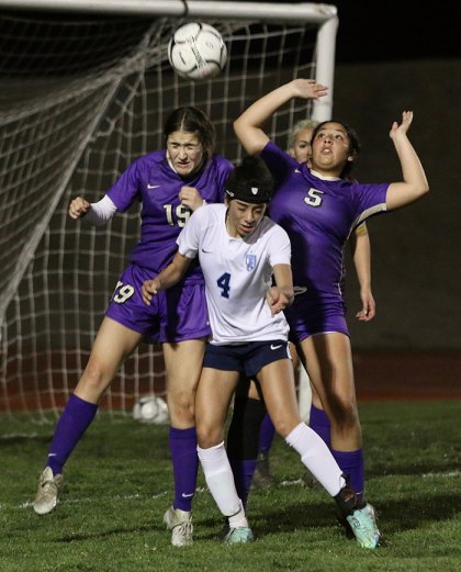 Lemoore's Jessica Padilla (5) and Madison Martinez (19) battle near the goal in Thursday's loss to visiting Redwood High School.